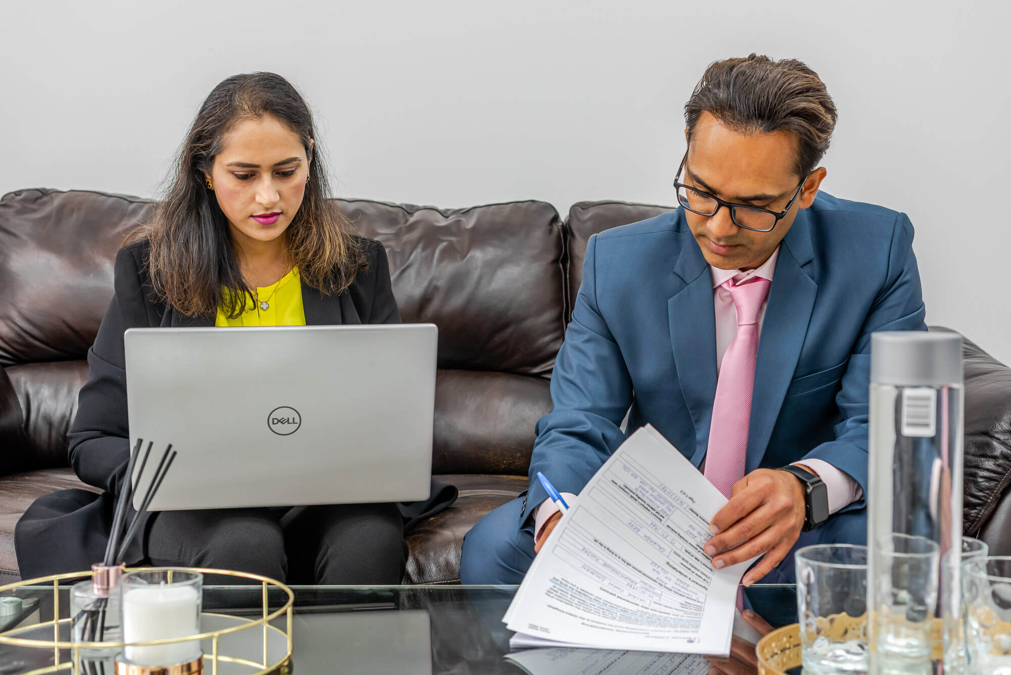 Saurabh Bedi consulting with a client, reviewing documents on laptop