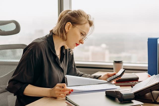 female accountant working at desk with paper in hand