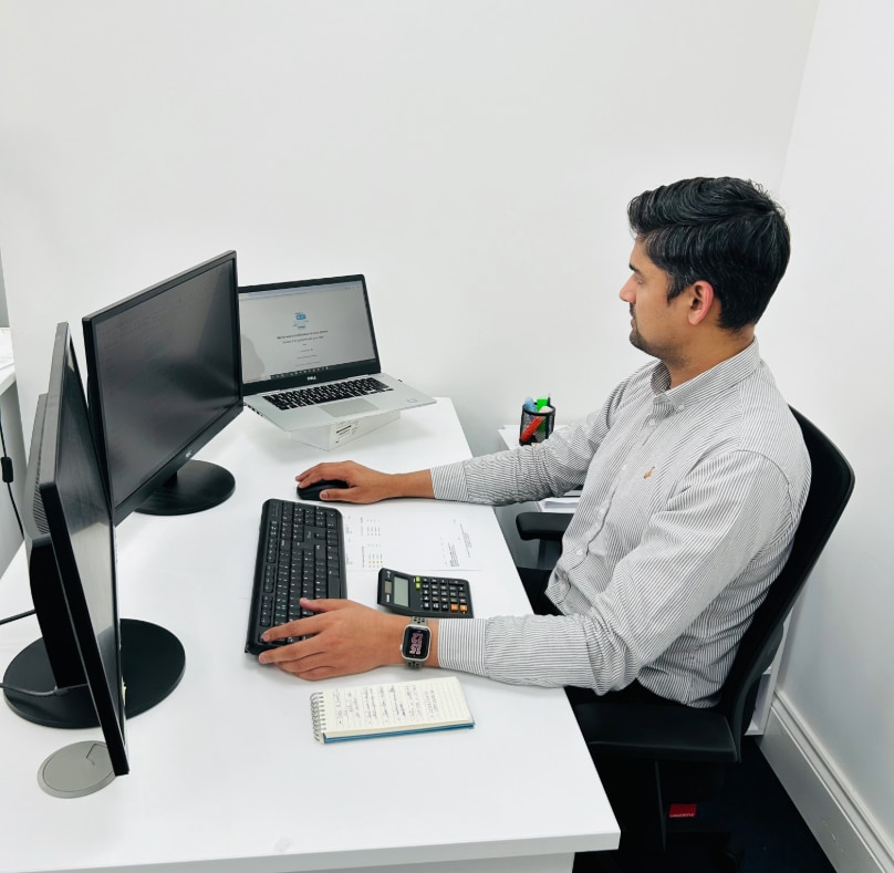A man sitting at a desk, working on tax audit